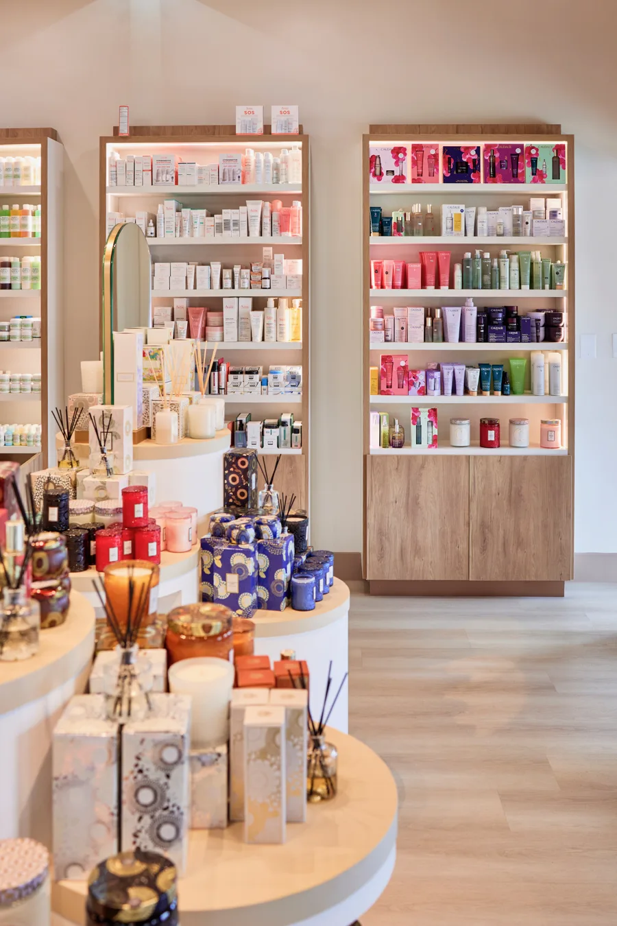 The retail floor at Sophia's Pharmacy — skincare wall and fragrance tables